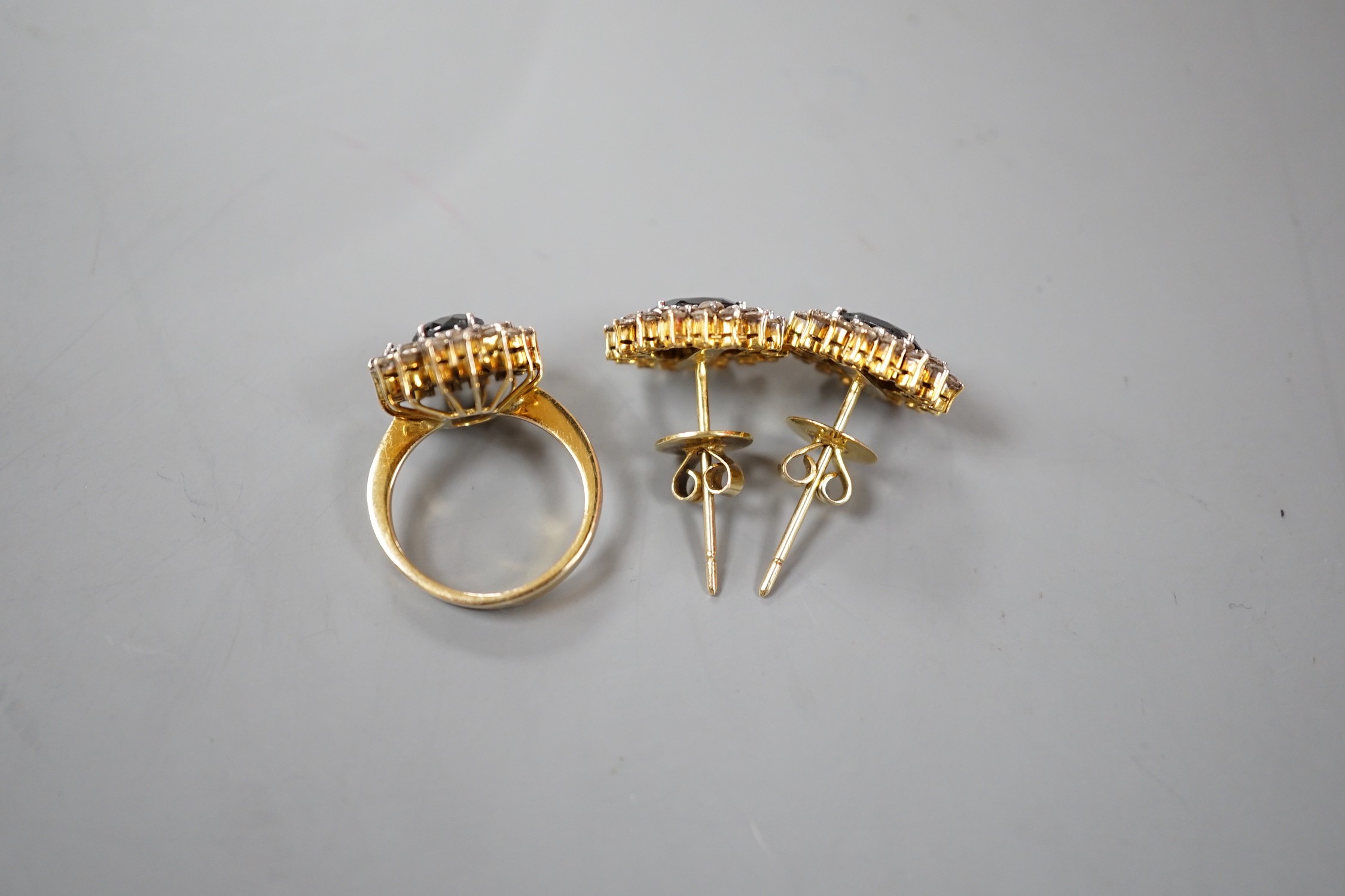 A modern suite of yellow metal, sapphire and diamond cluster set jewellery, comprising a ring, size H and a pair of earrings, 15mm, gross weight 10.4 grams.